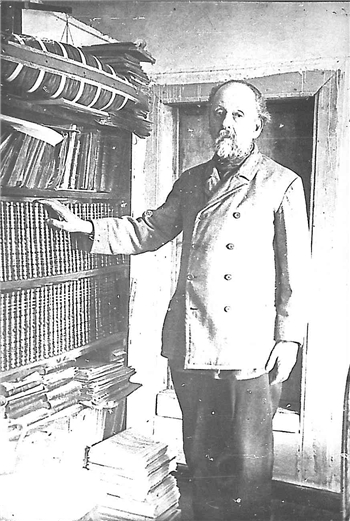 Konstantin Tsiolkovsky in his office near a shelf of books. 1927.