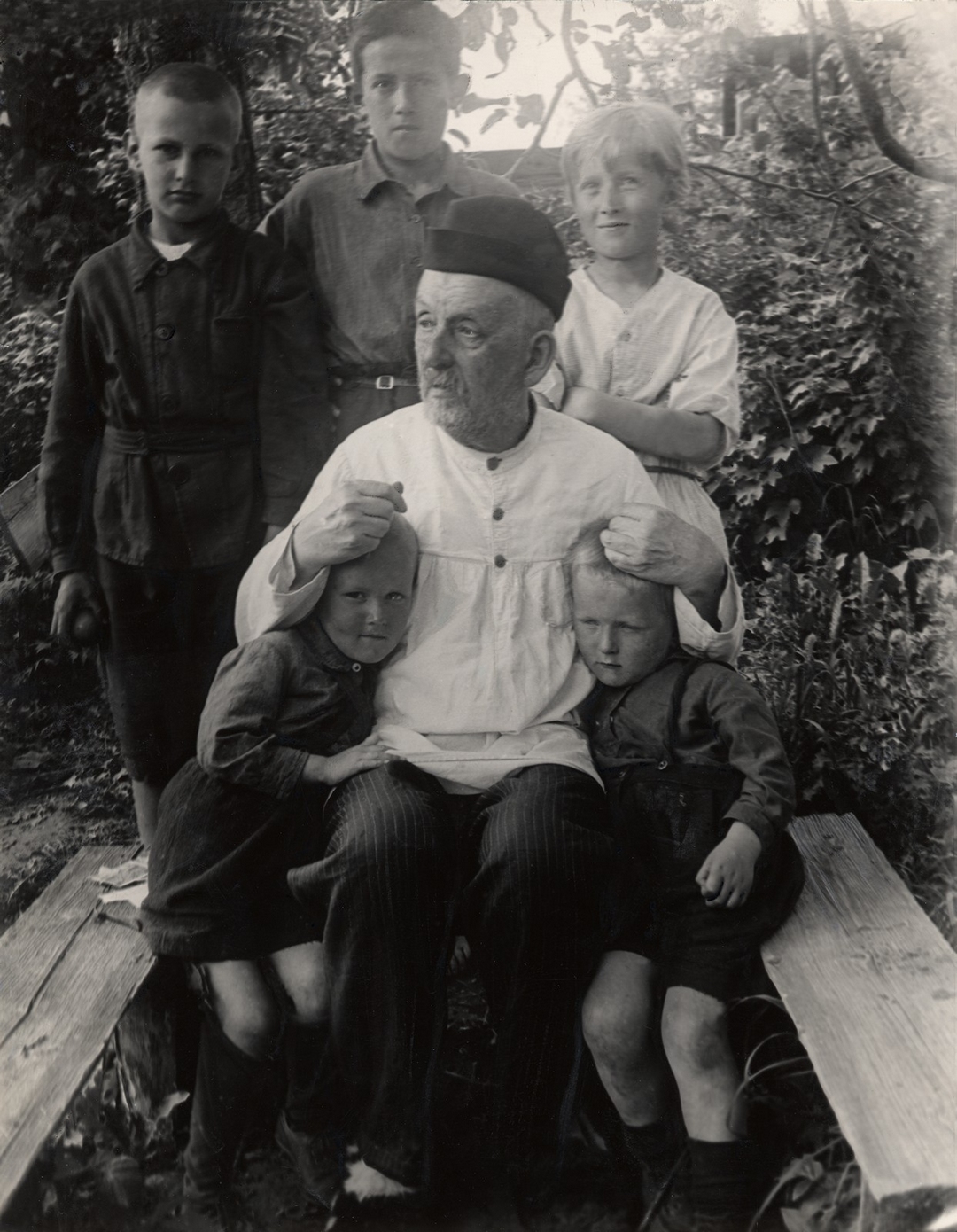 К.Э. Циолковский с внуками в саду своего дома. На снимке слева направо: сидят Леша Костин, Константин Эдуардович, Женя Костин, стоят Владимир Киселев, Вениамин и Муся Костины. 1932.  Автор: Нетужилин Александр Гаврилович (1909–1980). Источник: фонды ГМИК им. К. Э. Циолковского